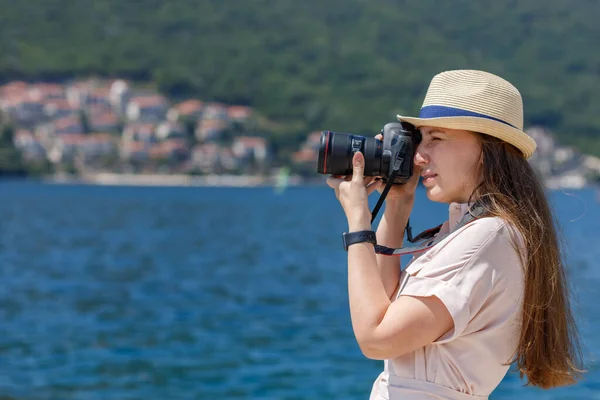 Young travel lady in dress takes photo with professional camera at sunny day — Stock Photo, Image