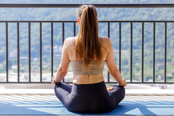 Junge Fitness-Frau entspannt und meditiert auf dem Balkon — Stockfoto