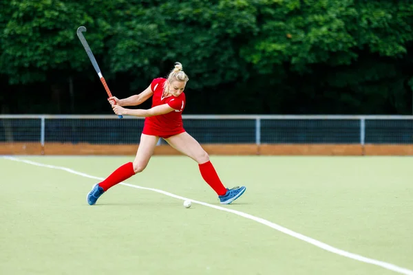 Young woman field hockey player hit the ball in attack on game — Stok fotoğraf
