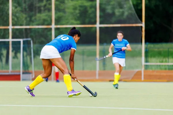 Young woman field hockey player leading the ball in attack — Stock Photo, Image