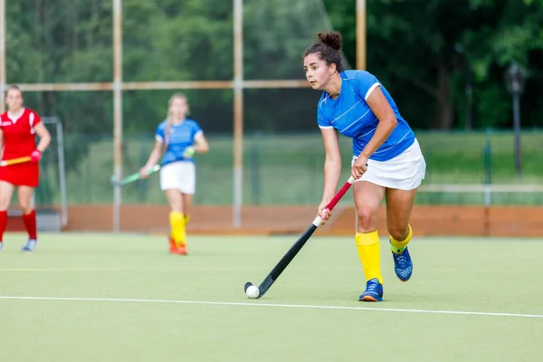 Young woman field hockey player leading the ball in attack