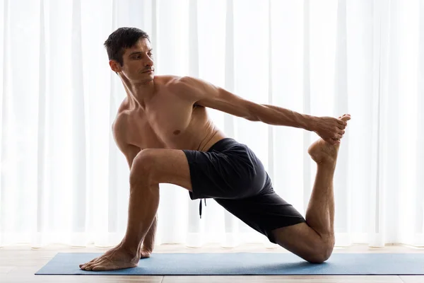 Ung Sportig Man Som Stretchar Benen Yogamattan Morgonträningen — Stockfoto