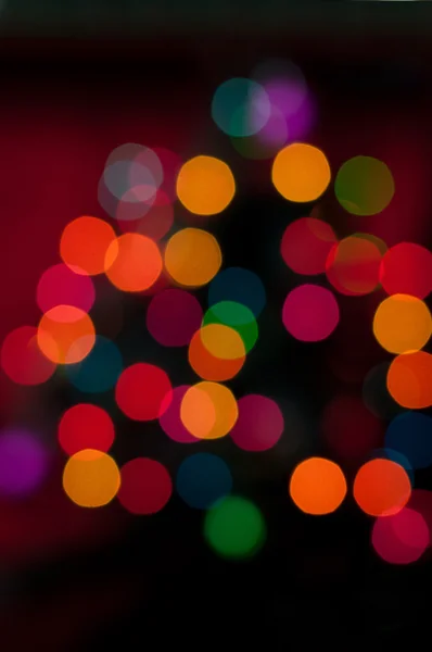 Weihnachtsbaum mit defokussierten Lichtern. roter Hintergrund — Stockfoto