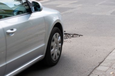 Asphalt holes on roadbed. Car in a motion. clipart