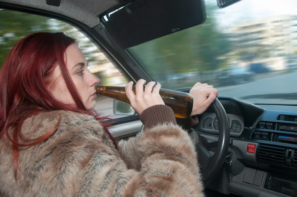 Drunk woman driving car with beer in hand — Stock Photo, Image