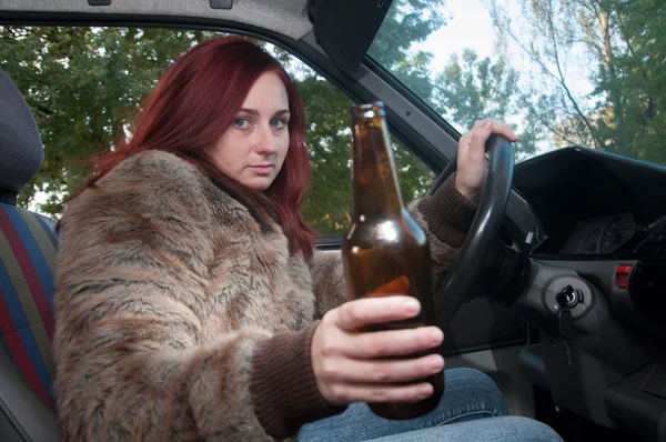 Drunk woman driving car with beer in hand — Stock Photo, Image