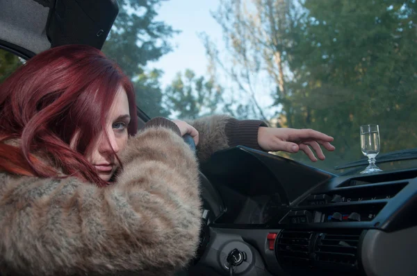 Drunk woman driving car with vodka in hand — Stock Photo, Image