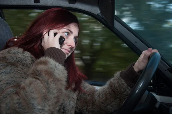 Woman talking on the phone while driving — Stock Photo, Image