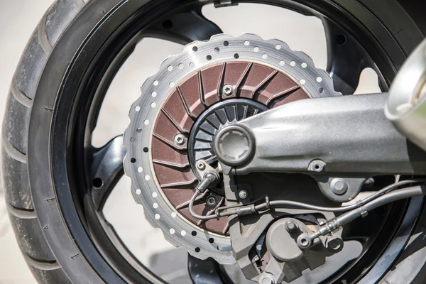 Close up of a motorcycle's front wheel and brake disc — Stock Photo, Image