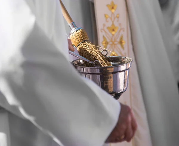 Католический священник со святой водой — стоковое фото