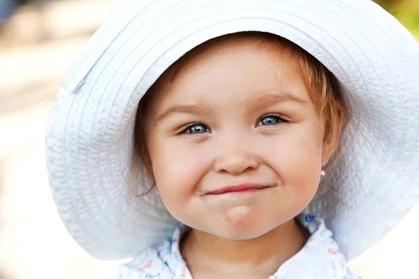 Χαμογελαστό κορίτσι σε ένα λευκό καπέλο — Φωτογραφία Αρχείου