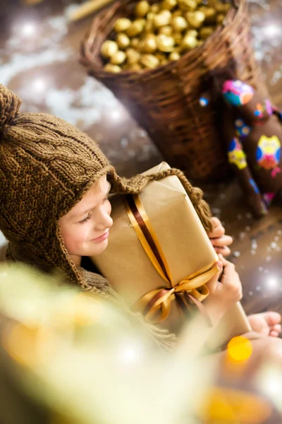 Lachende jongen houdt de giften van Kerstmis in zijn handen — Stockfoto