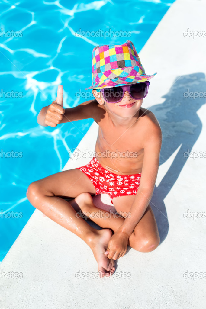 Cute boy on vacation next to the waterpool