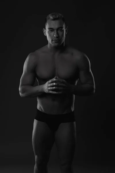 Der Oberkörper eines attraktiven männlichen Bodybuilders auf schwarzem Hintergrund. — Stockfoto