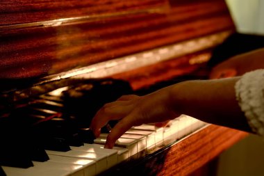 Kadın eli, piyano çalan kız, parmakları yakın, yatay görüntü.