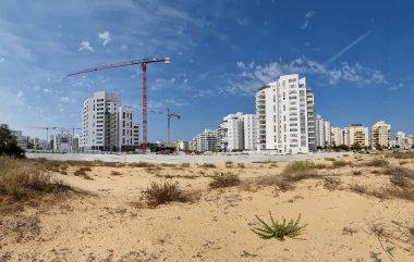Çöl kumulları arasında şehir inşaatı. İsrail 'deki Holon şehrinin yeni bir bölgesinde konut inşaatı.