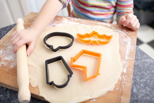 Uma menina está fazendo biscoitos para decoração halloween no — Fotografia de Stock