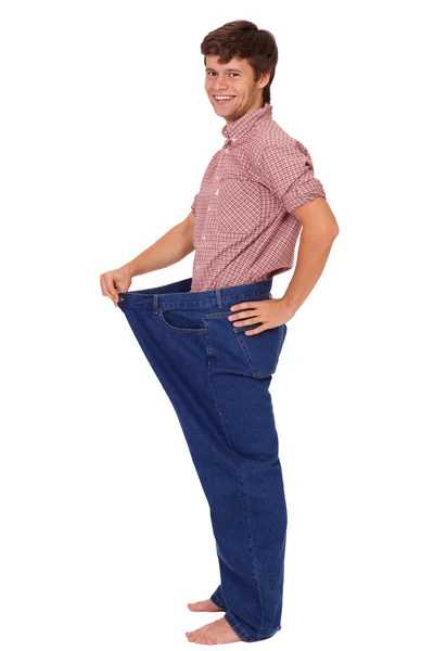 Mladý štíhlý šťastný fešák v džínách, izolované na bílém — Stock fotografie