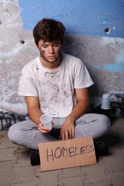 evsiz bir sokakta oturan yardım için soruyorum