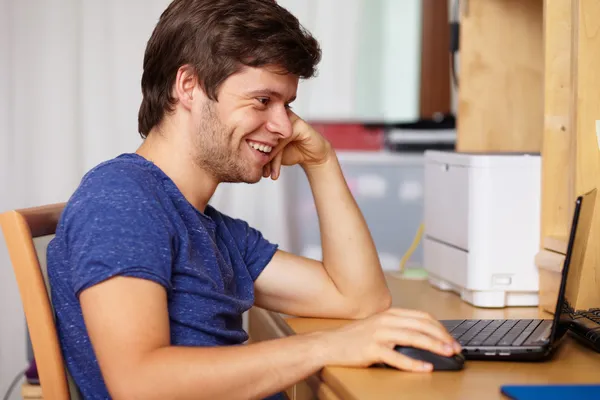 Ung snygg kille med laptop, bakgrund — Stockfoto