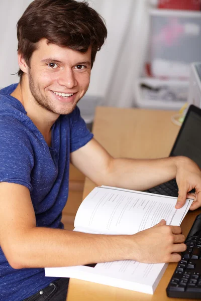 Joven chico guapo con portátil y libro, fondo — Foto de Stock