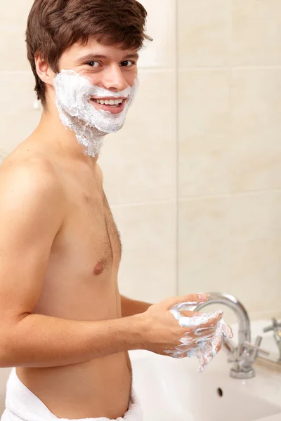 Young handsome smiling guy with a tovel, background — Stock Photo, Image