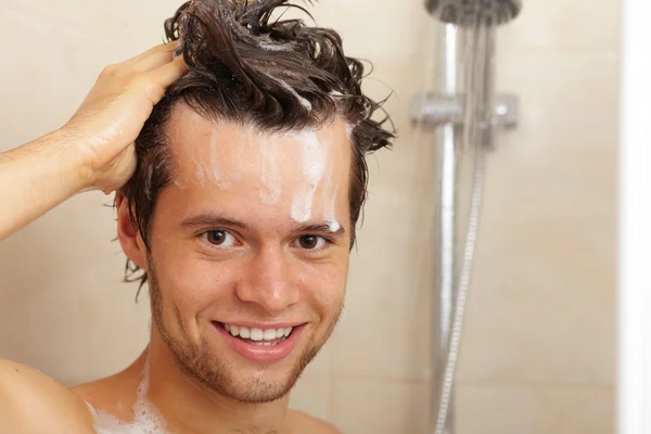 Joven guapo sonriente chico tomando ducha — Foto de Stock