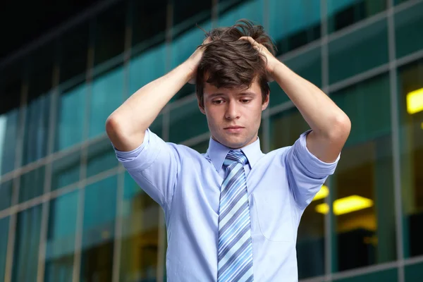 Portrait of upset stressed handsome businessman,building at back — Stock Photo, Image