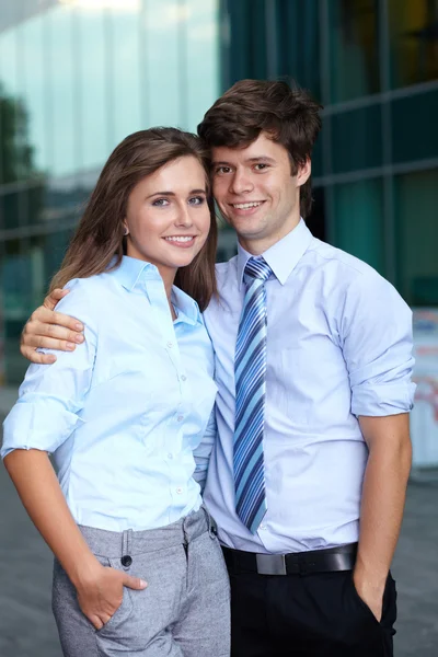 Portrait d'un jeune couple d'affaires debout ensemble, backgroun — Photo