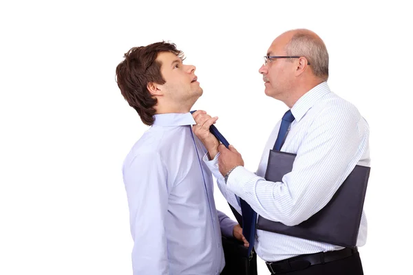 Senior businessman tearing young businessman at his tie, isolate — Stock Photo, Image