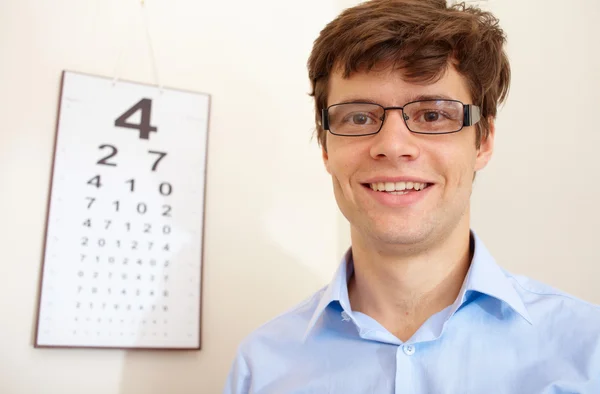 Atraktivní mladý muž s oko chart za — Stock fotografie