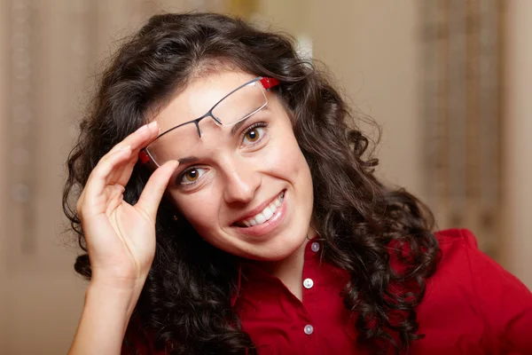 Mujer joven en óptico con gafas, fondo en óptico sho —  Fotos de Stock