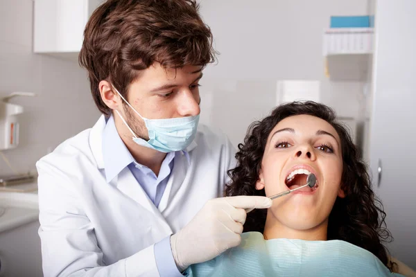 Dentiste avec miroir vérifiant patient — Photo