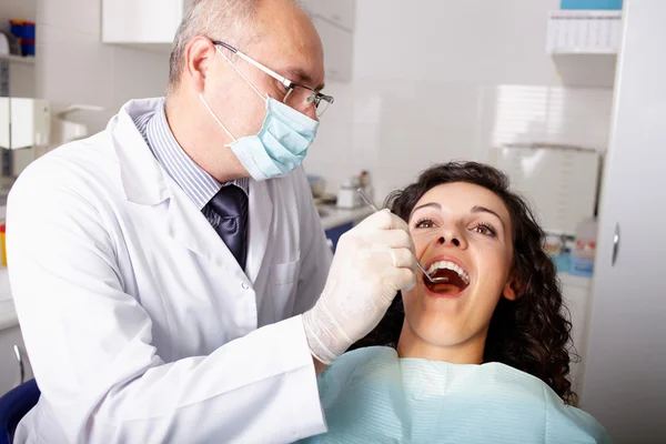 Οδοντίατρος με καθρέφτη, τον έλεγχο των δοντιών του ασθενούς Φωτογραφία Αρχείου