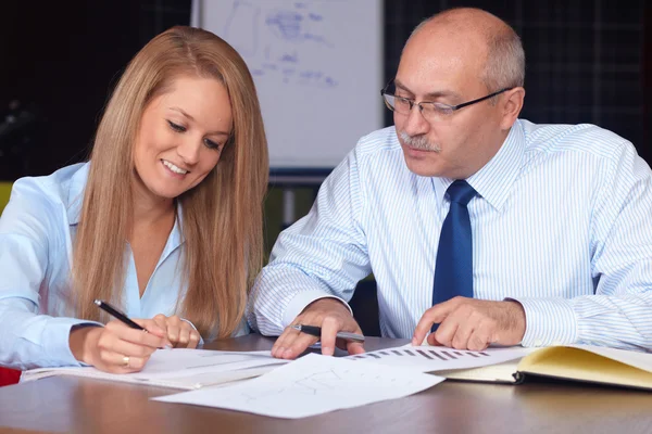 Jeune femme d'affaires discuter avec un homme d'affaires senior, fond — Photo