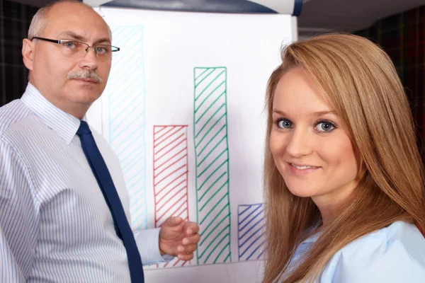 Senior affärsman närvarande graf till ung affärskvinna, ba — Stockfoto