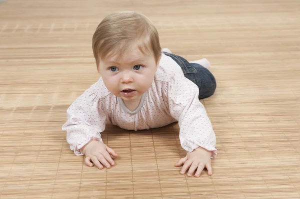 Gelukkig babymeisje op de vloer liggen — Stockfoto