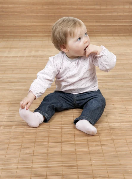 Bebê sentado em um piso de bambu — Fotografia de Stock