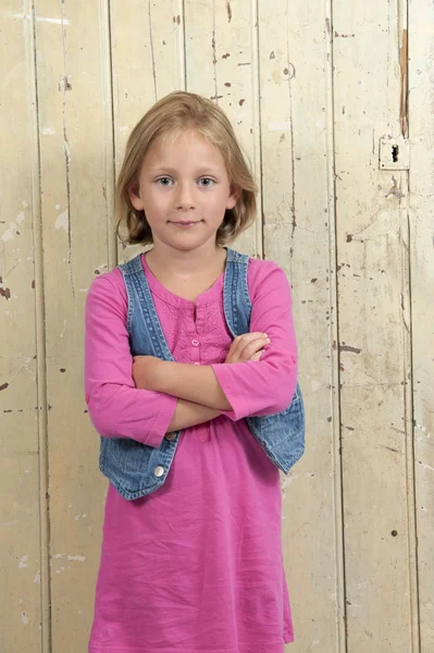 Blond girl in pink, arms crossed — Stock Photo, Image