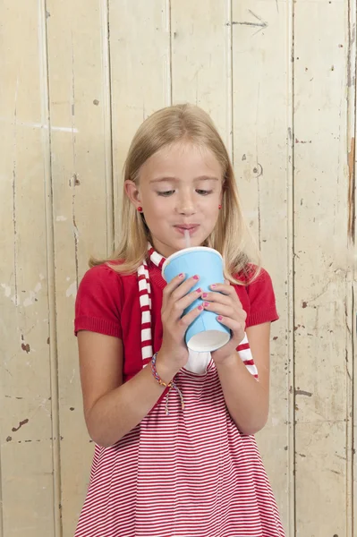 Menina em vermelho beber um refrigerante — Fotografia de Stock