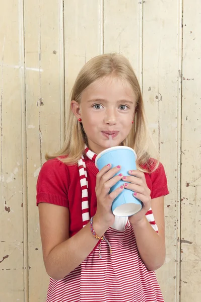 Menina em vermelho beber um refrigerante — Fotografia de Stock