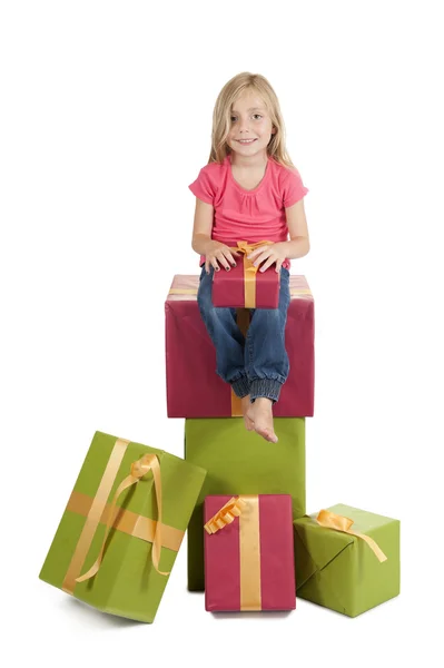 Meisje, zittend op een stapel van verjaardag presenteert — Stockfoto