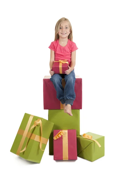 Niña sentada en una pila de regalos de cumpleaños —  Fotos de Stock