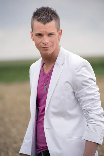 Young man in white coat ourdoors in the fields — Stock Photo, Image