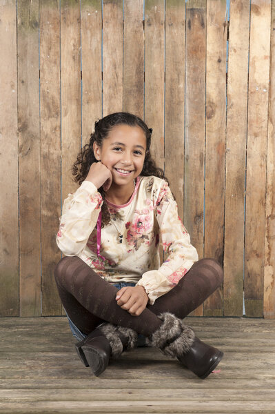 Girl seated on a old wooden floor