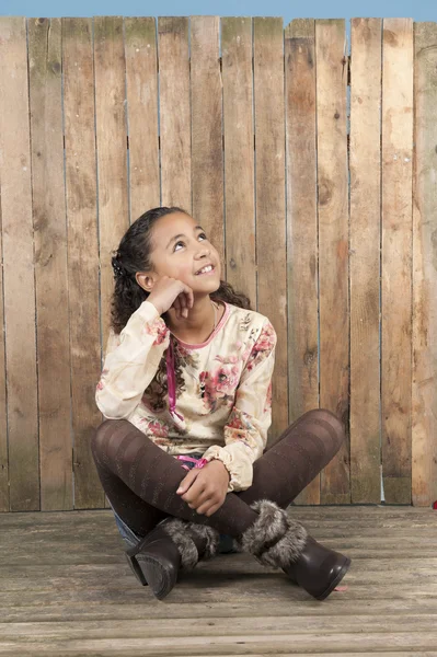 Mädchen sitzt auf einem alten Holzboden — Stockfoto
