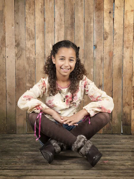 Girl seated on a old wooden floor — Stock Photo, Image