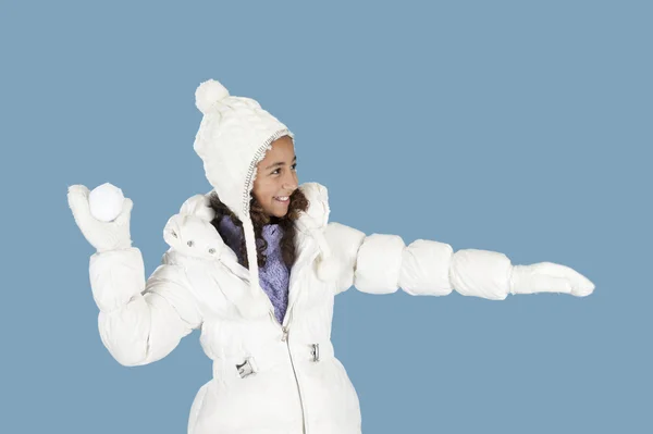 GIRL IN WNTER CLOTHES WROWING A SNOW BALL — Fotografia de Stock