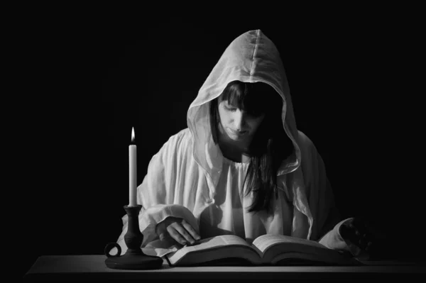 Femme de lecture en blanc, avec bougie — Photo