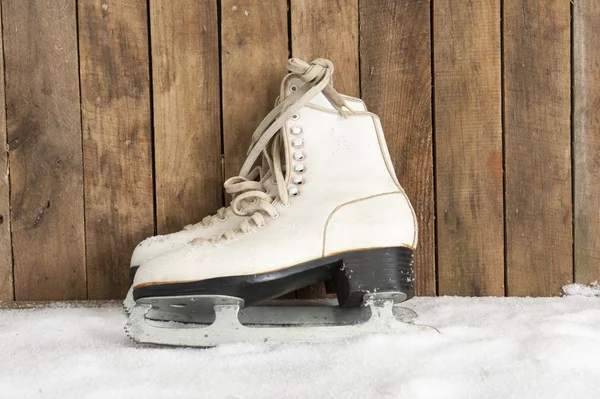Pattini su ghiaccio contro una parete di legno intemperie — Foto Stock